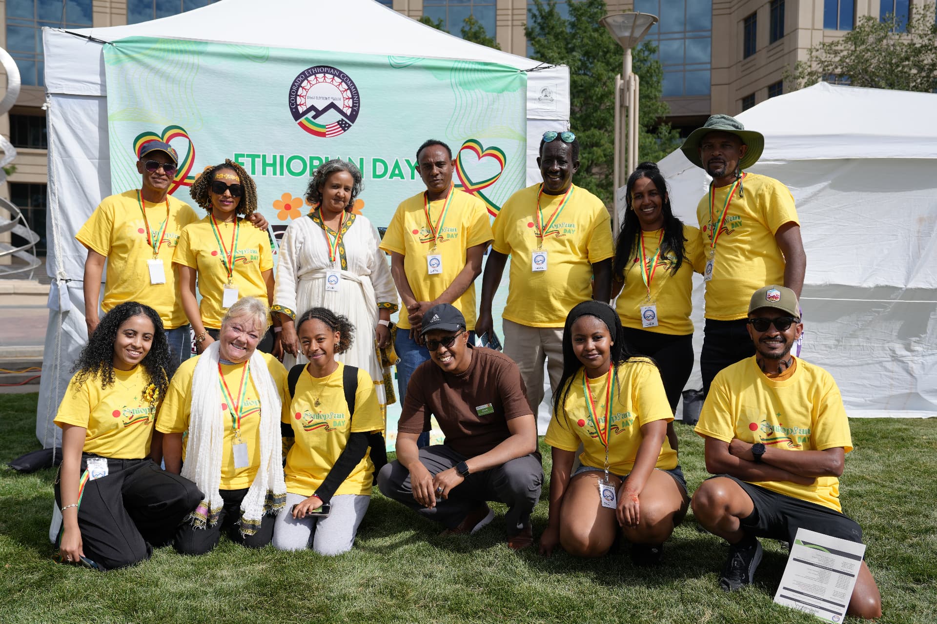 Colorado Ethiopian Community volunteers in Ethiopian Day t-shirts gathered in front of the event banner